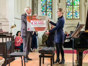 Manon Veenendaal (NMF) ontvangt een cheque van voorzitter Peter Scheerder (Delden Klassiek).